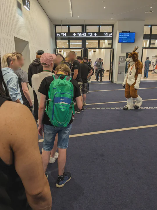 Photo taken while standing in queue for the Dealer’s Den, a line of people in front of me, with a deer fursuiter looking at us